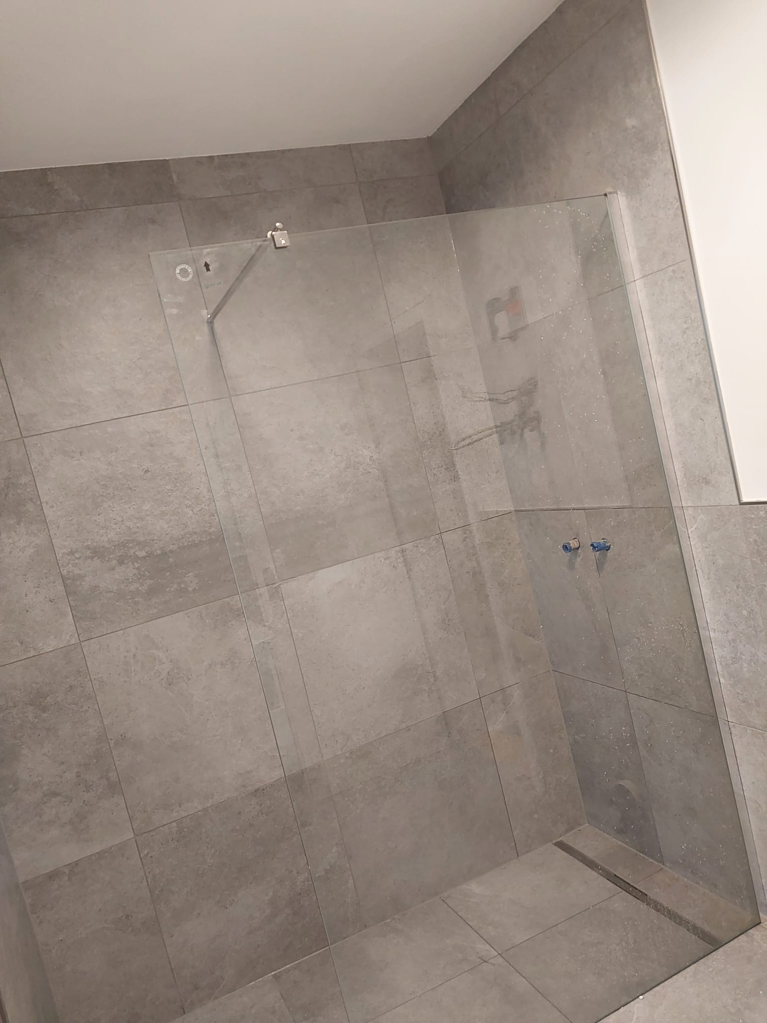 Fliesenarbeiten mit ruhigem Duschbereich und großformatigen Fliesen